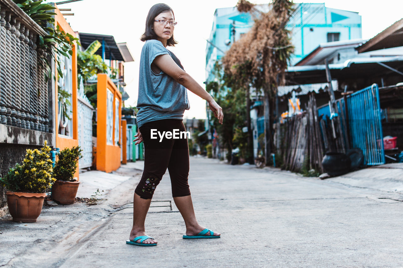 Full length portrait of woman walking on the street. 