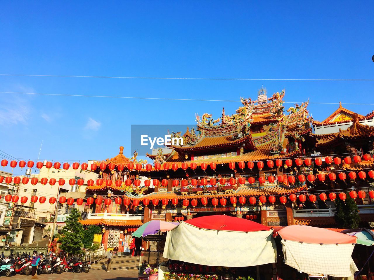 GROUP OF PEOPLE BY BUILDINGS AGAINST SKY