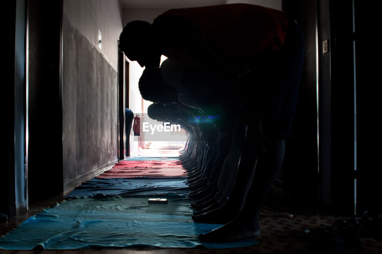 Men exercising while standing in corridor