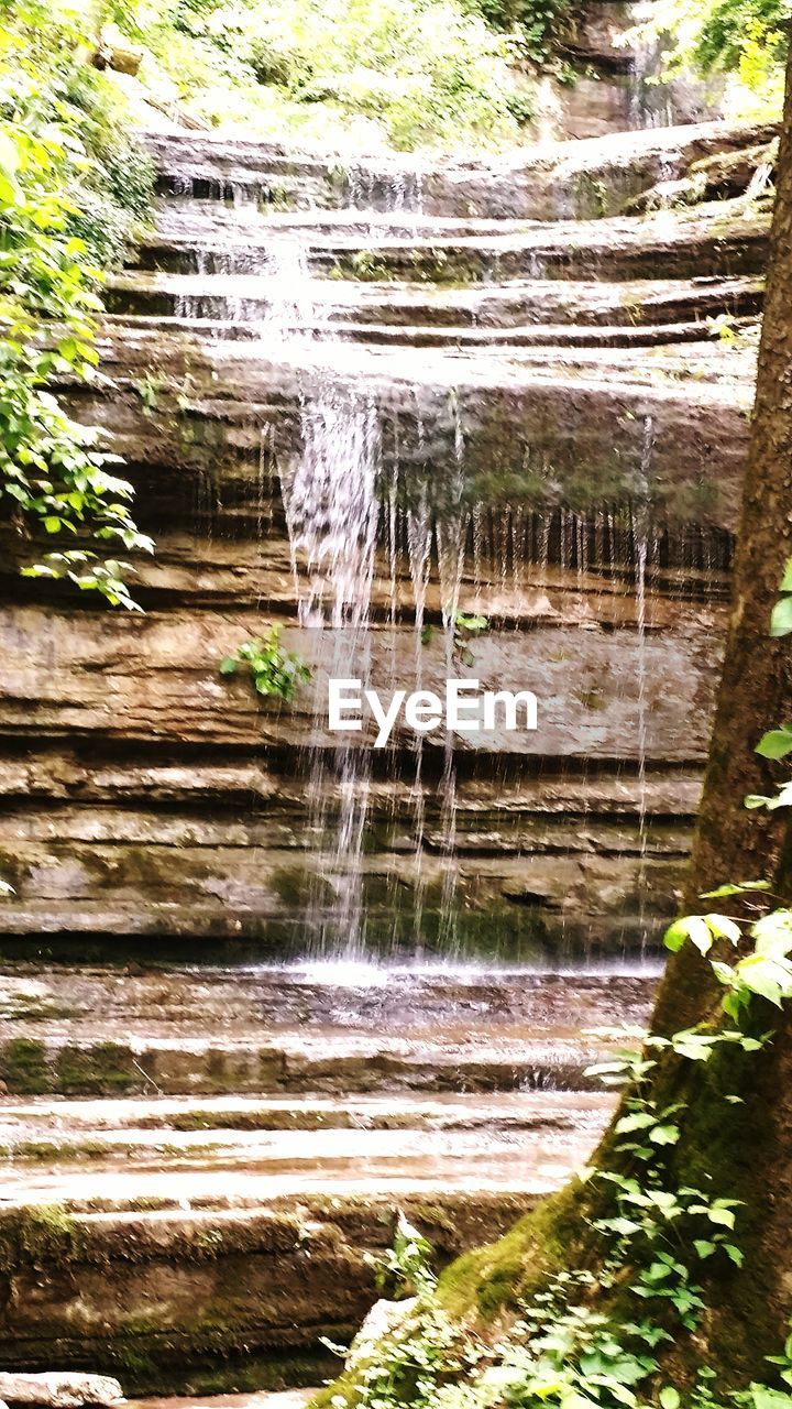 SCENIC VIEW OF WATER FLOWING THROUGH ROCKS