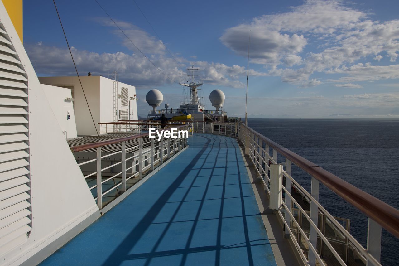 passenger ship, sky, water, sea, vehicle, architecture, cruise ship, ship, nature, transportation, railing, cloud, built structure, travel, nautical vessel, yacht, outdoors, day, blue, horizon, mode of transportation, building exterior, horizon over water, travel destinations, watercraft, boat, tourism, no people, boat deck, business, cruise, deck