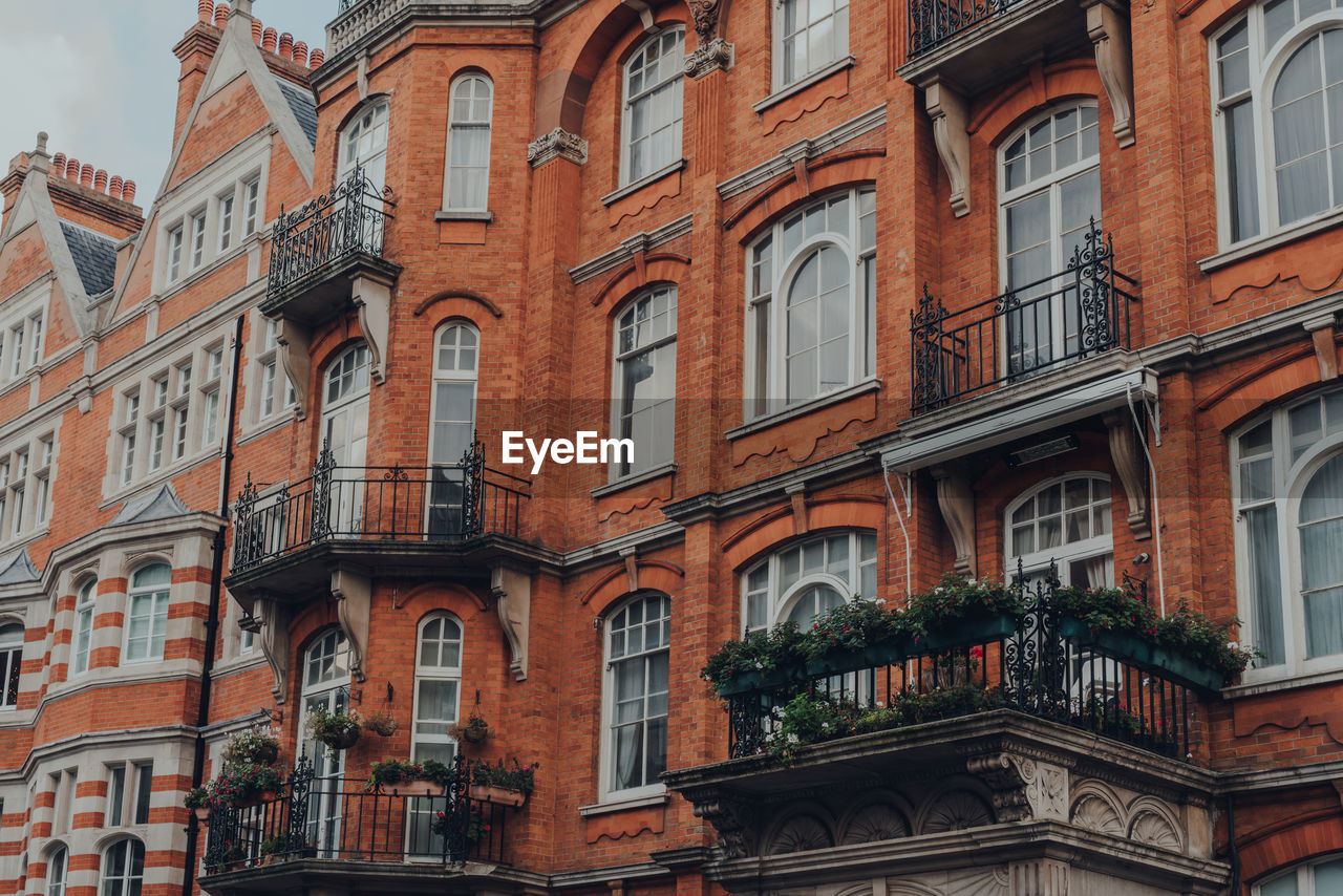 Traditional red brick apartment block with balconies in mayfair, london, uk.