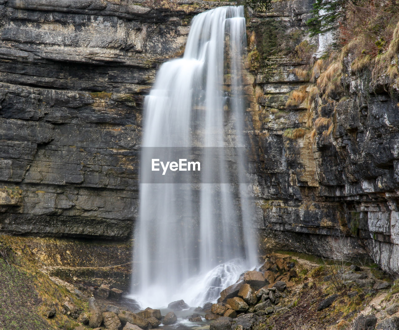 SCENIC VIEW OF WATERFALL AGAINST ROCK