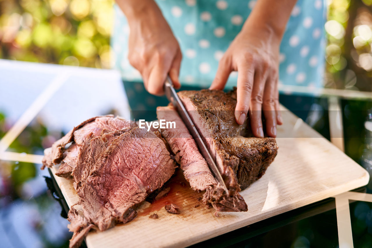 cropped hand of man preparing food on cutting board