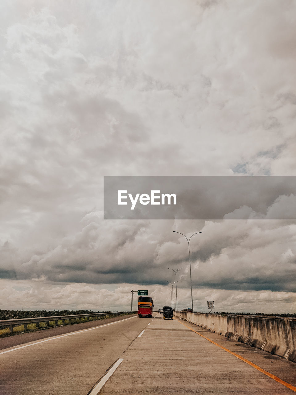 Car on road against cloudy sky