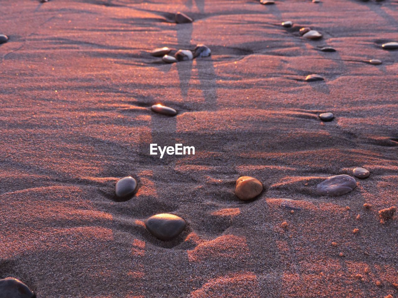 CLOSE-UP OF STONES ON SAND
