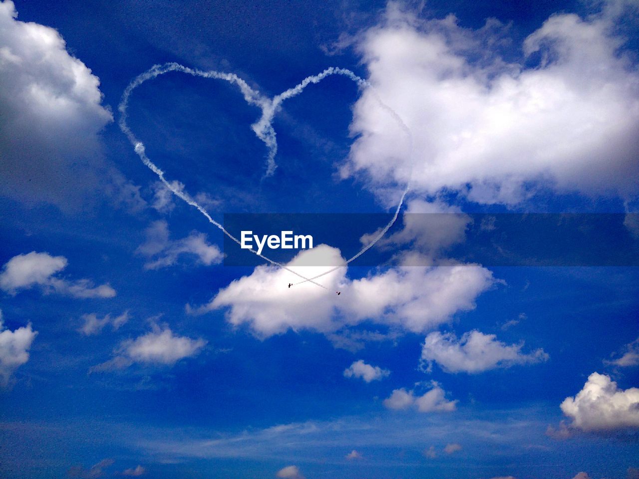 Low angle view of vapor trail against blue sky