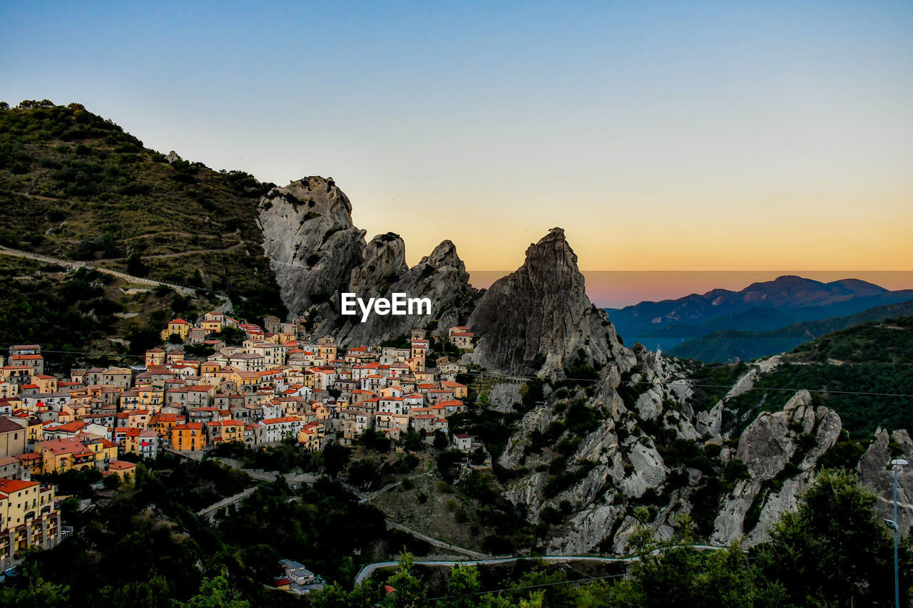 Panoramic view of townscape and mountains against clear sky