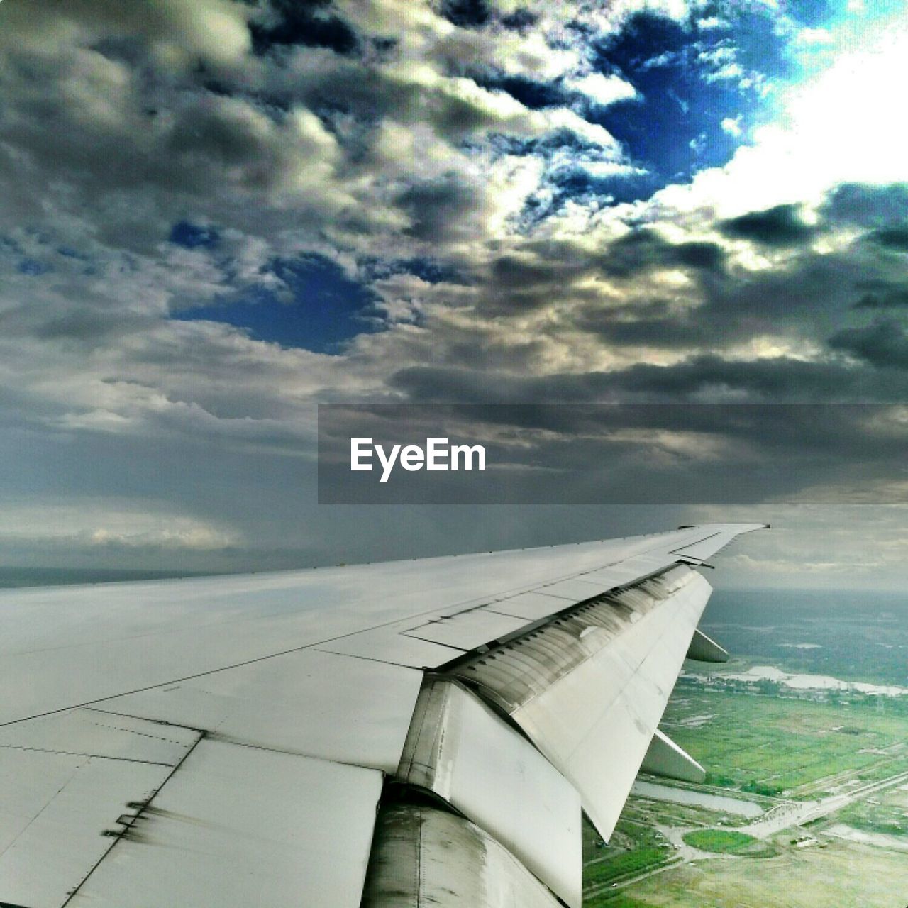 LOW ANGLE VIEW OF CROPPED AIRPLANE AGAINST CLOUDY SKY