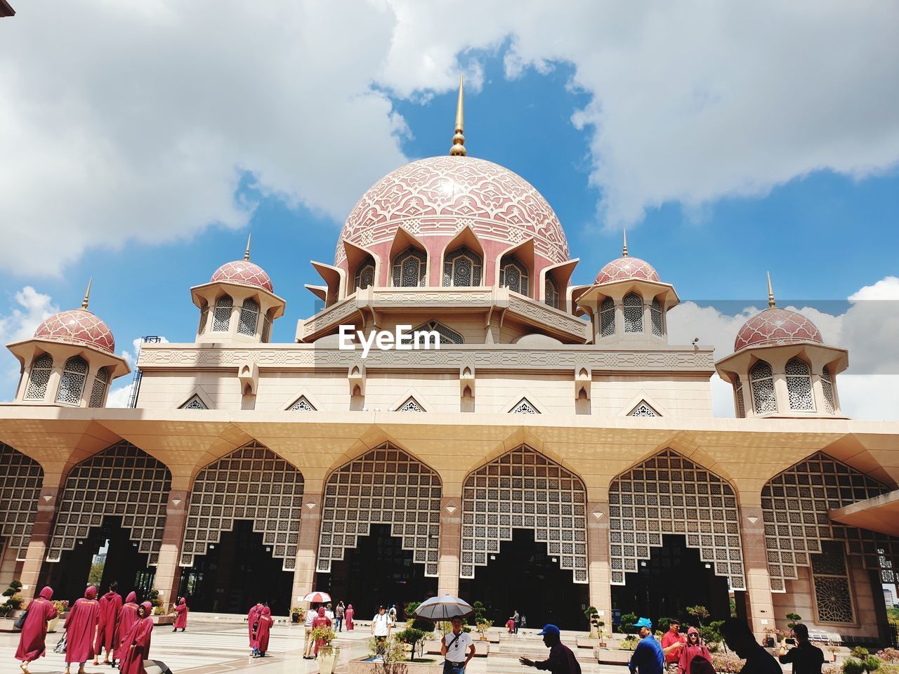 GROUP OF PEOPLE IN TRADITIONAL BUILDING AGAINST SKY