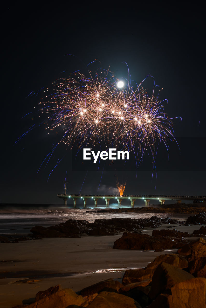 Firework display over sea against sky at night in the city of gqeberha