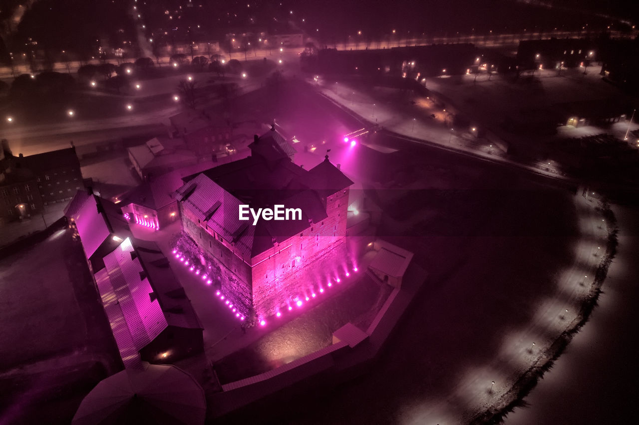 HIGH ANGLE VIEW OF ILLUMINATED BUILDING IN CITY AT NIGHT