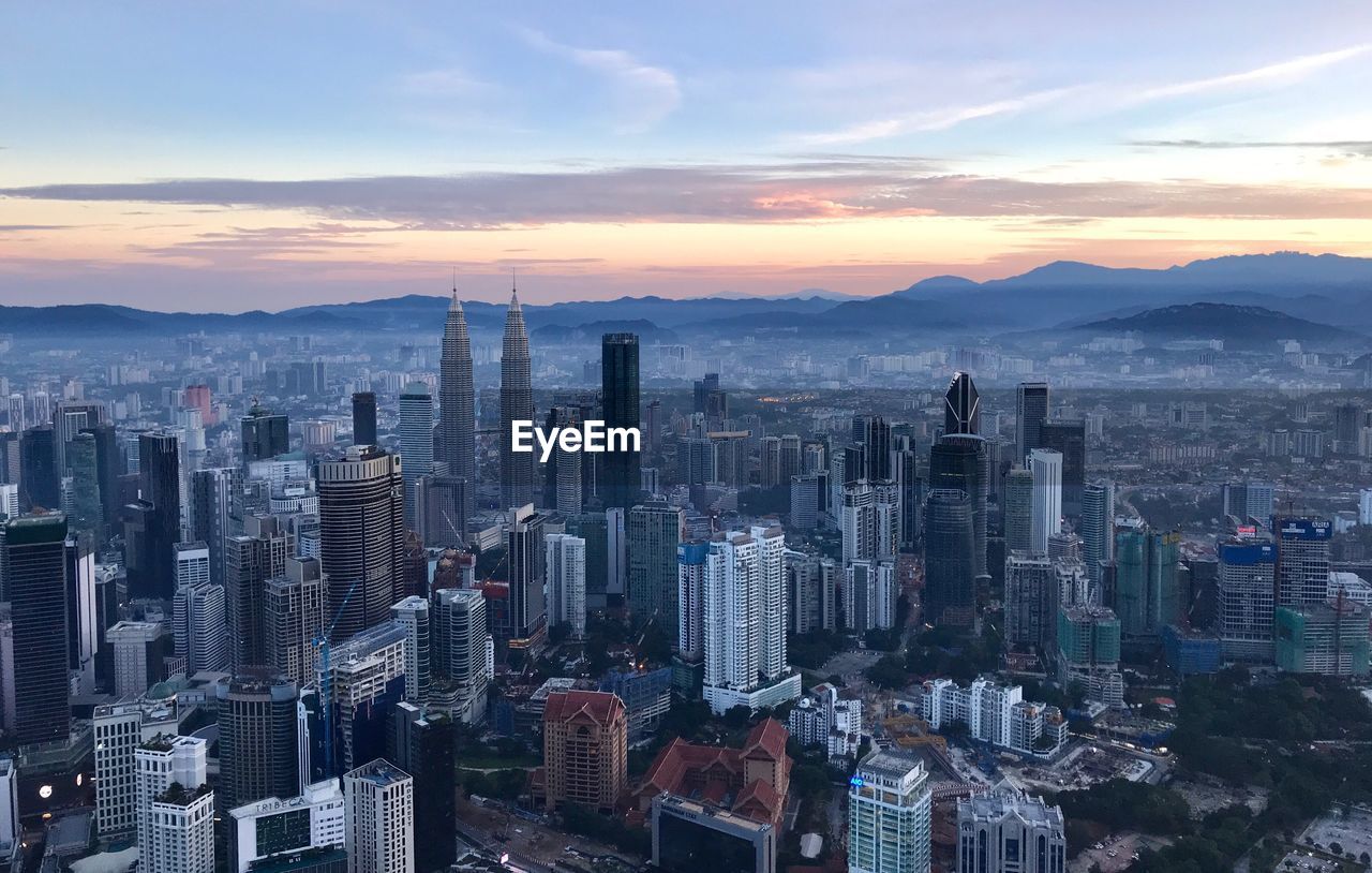 Aerial view of buildings in city during sunset