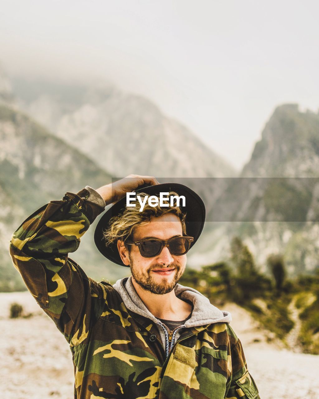 Portrait of man wearing sunglasses against mountains