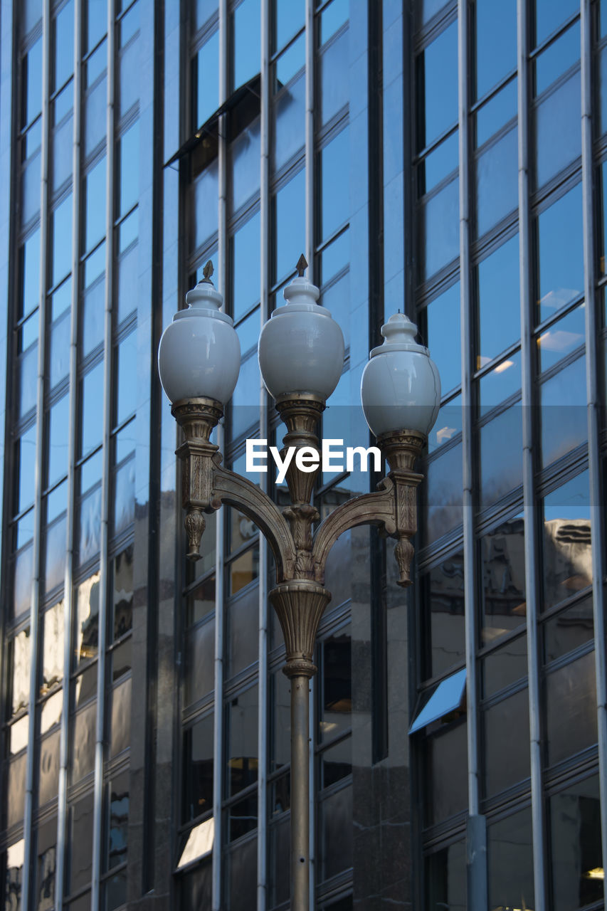 Low angle view of street light against modern building