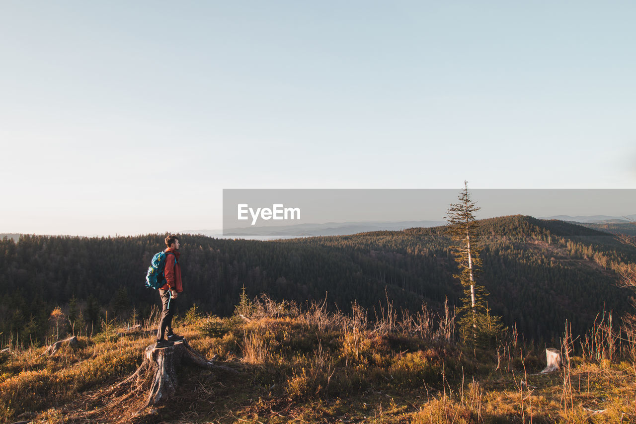 Active hiker enjoys the feeling of reaching the top of the mountain at sunrise. hiker is enlightened