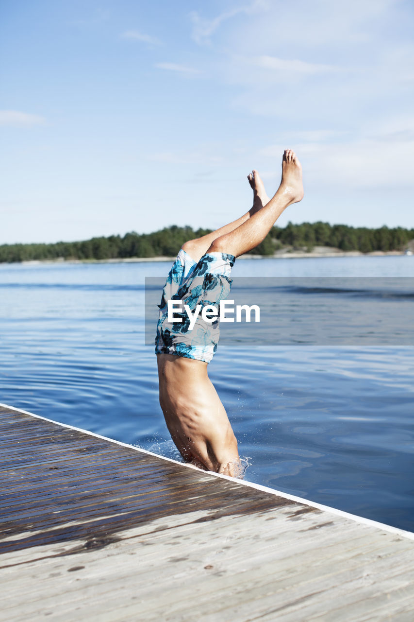 Teenage boy jumping into water