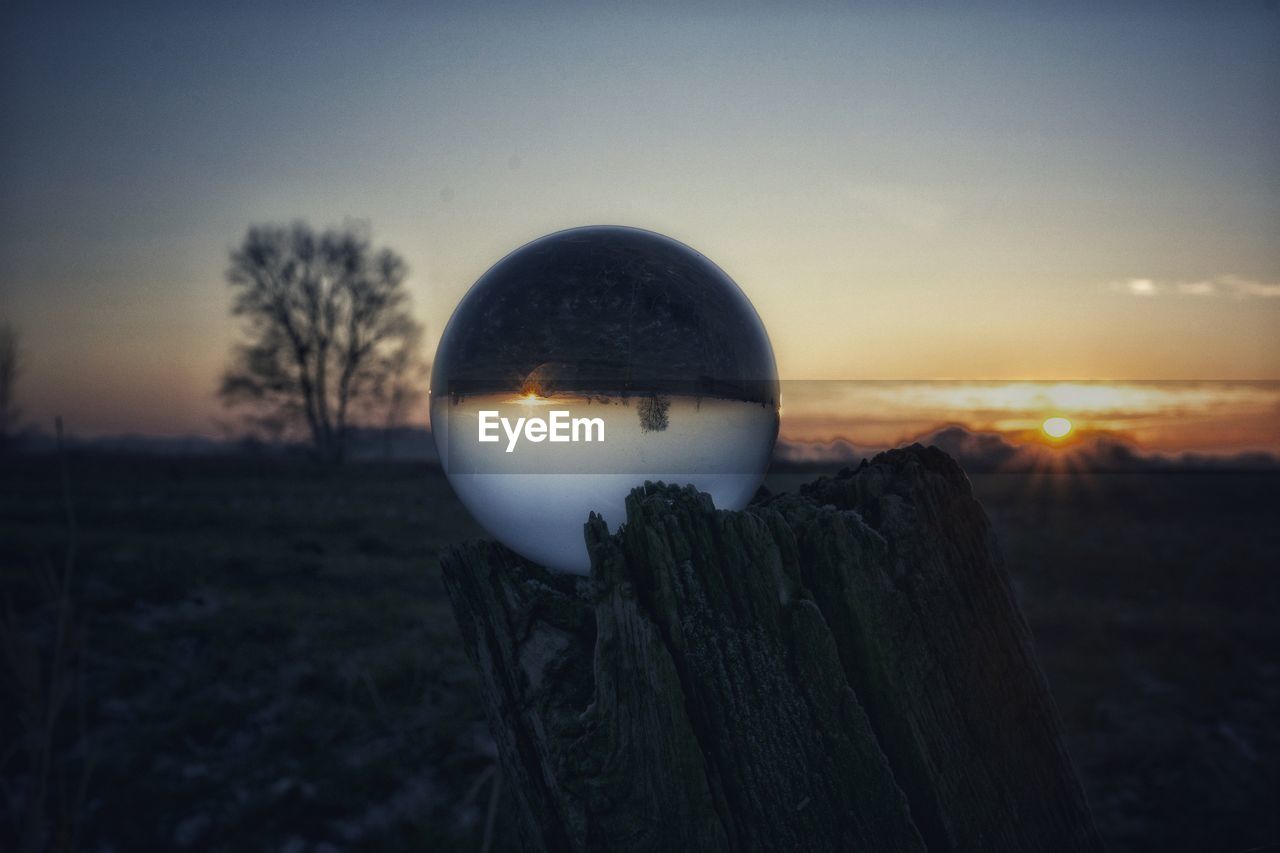 CLOSE-UP OF WOODEN POST AT SUNSET