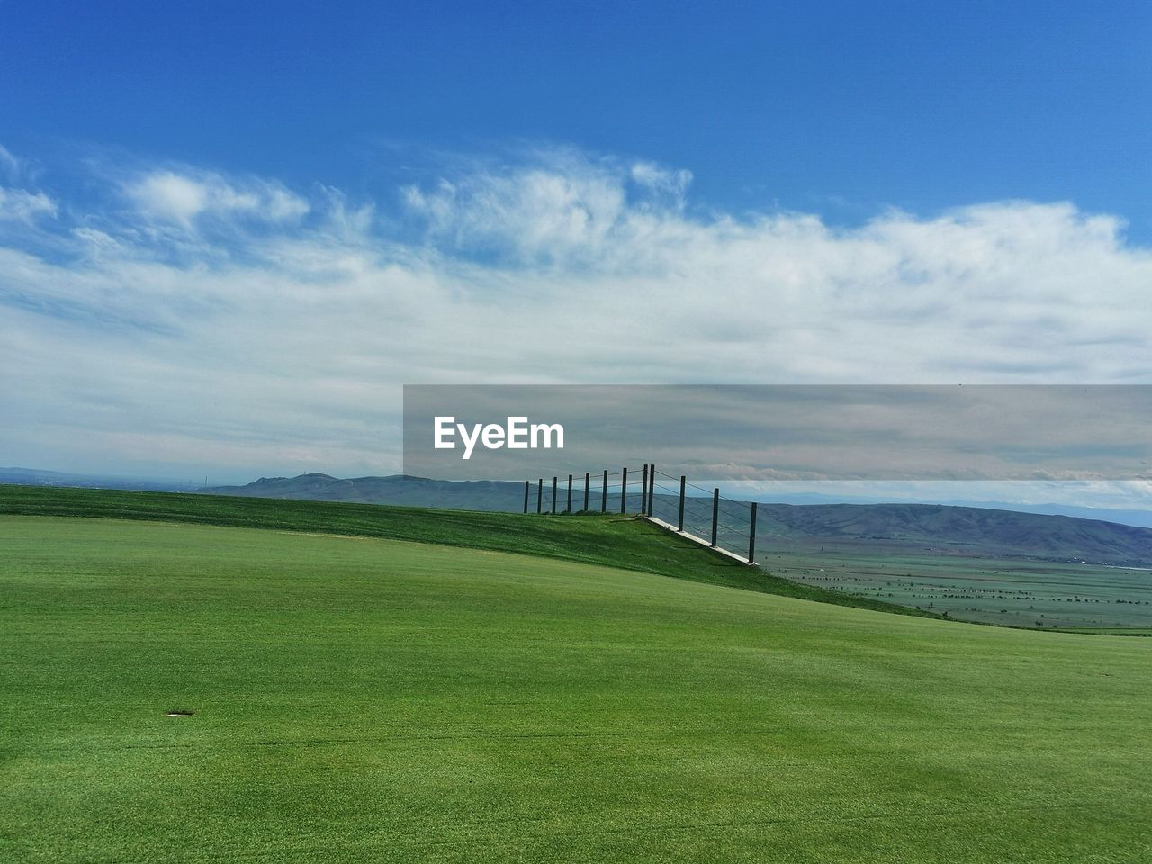 Scenic view of golf course against sky