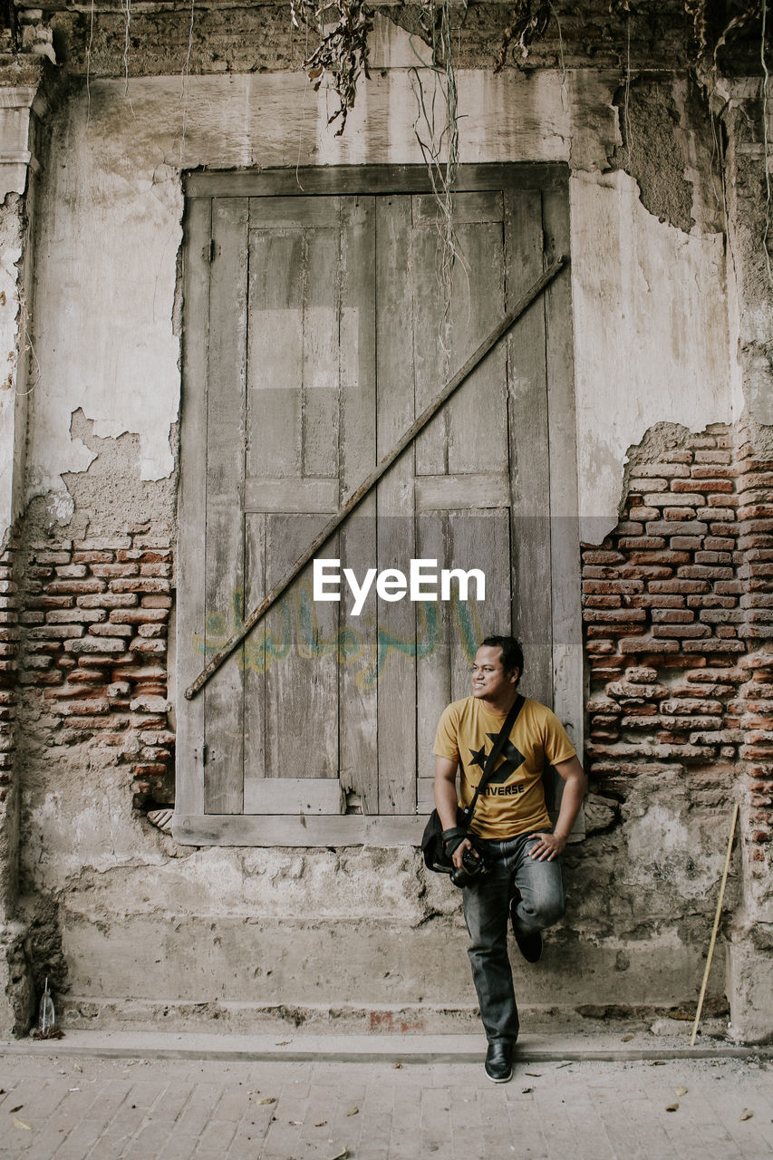 Full length of man on wall of building