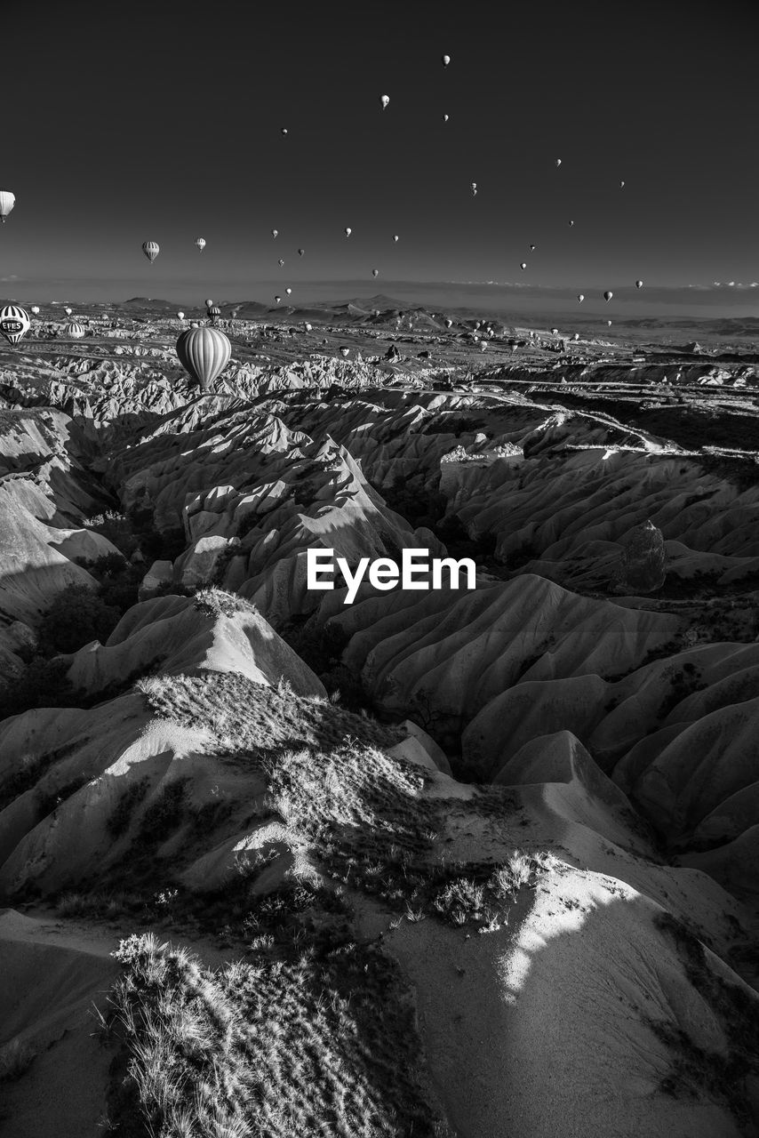 Hot air balloons over rocky mountains at cappadocia