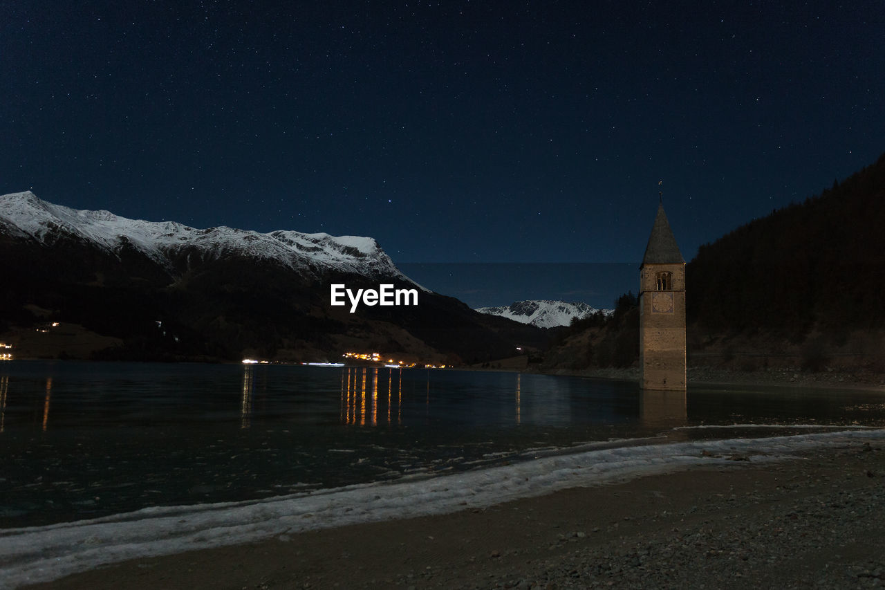 Scenic view of snowcapped mountains against sky at night