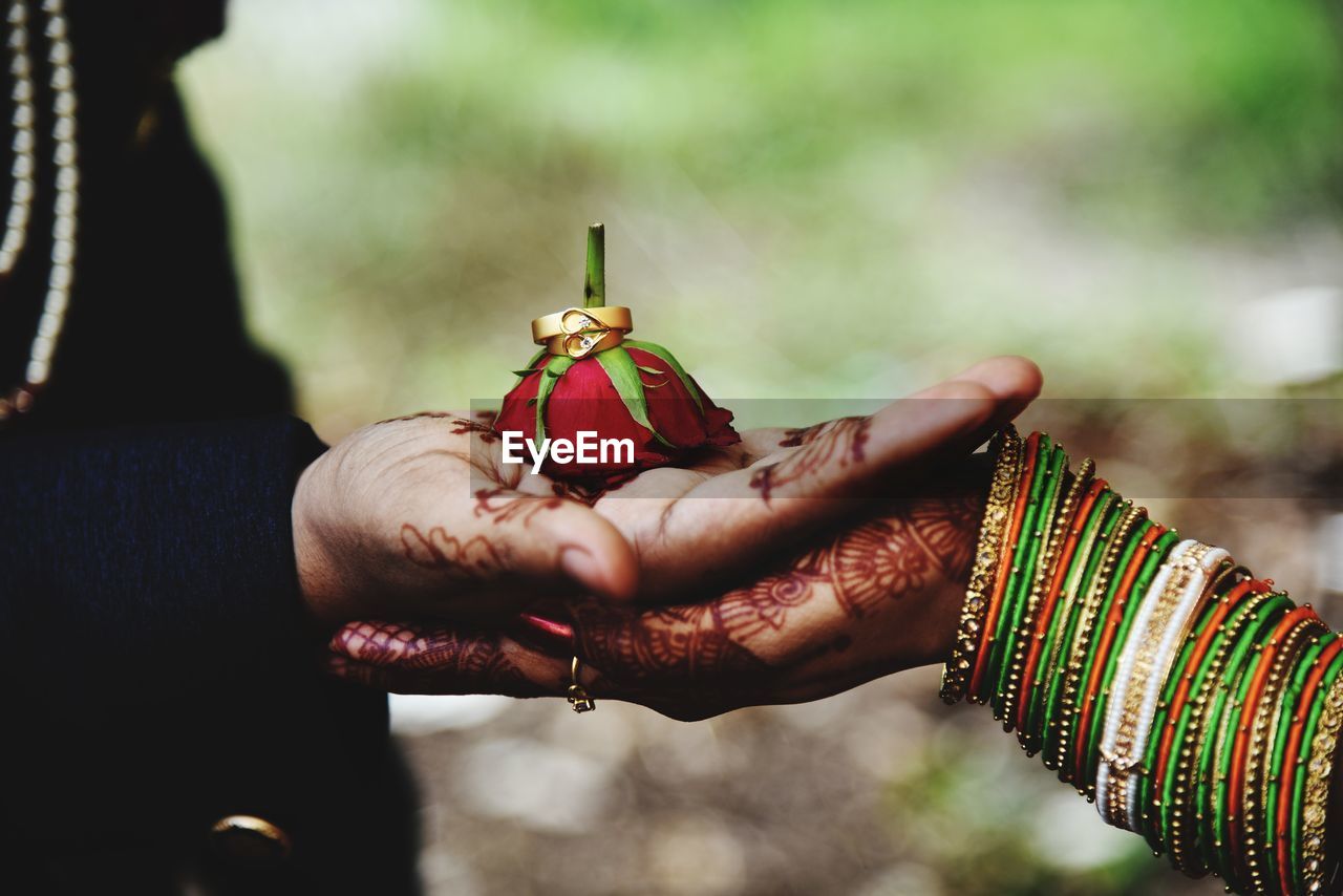 Close-up of hand holding red bell outdoors
