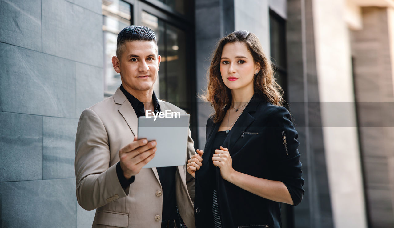 Portrait of business people standing by building outdoors