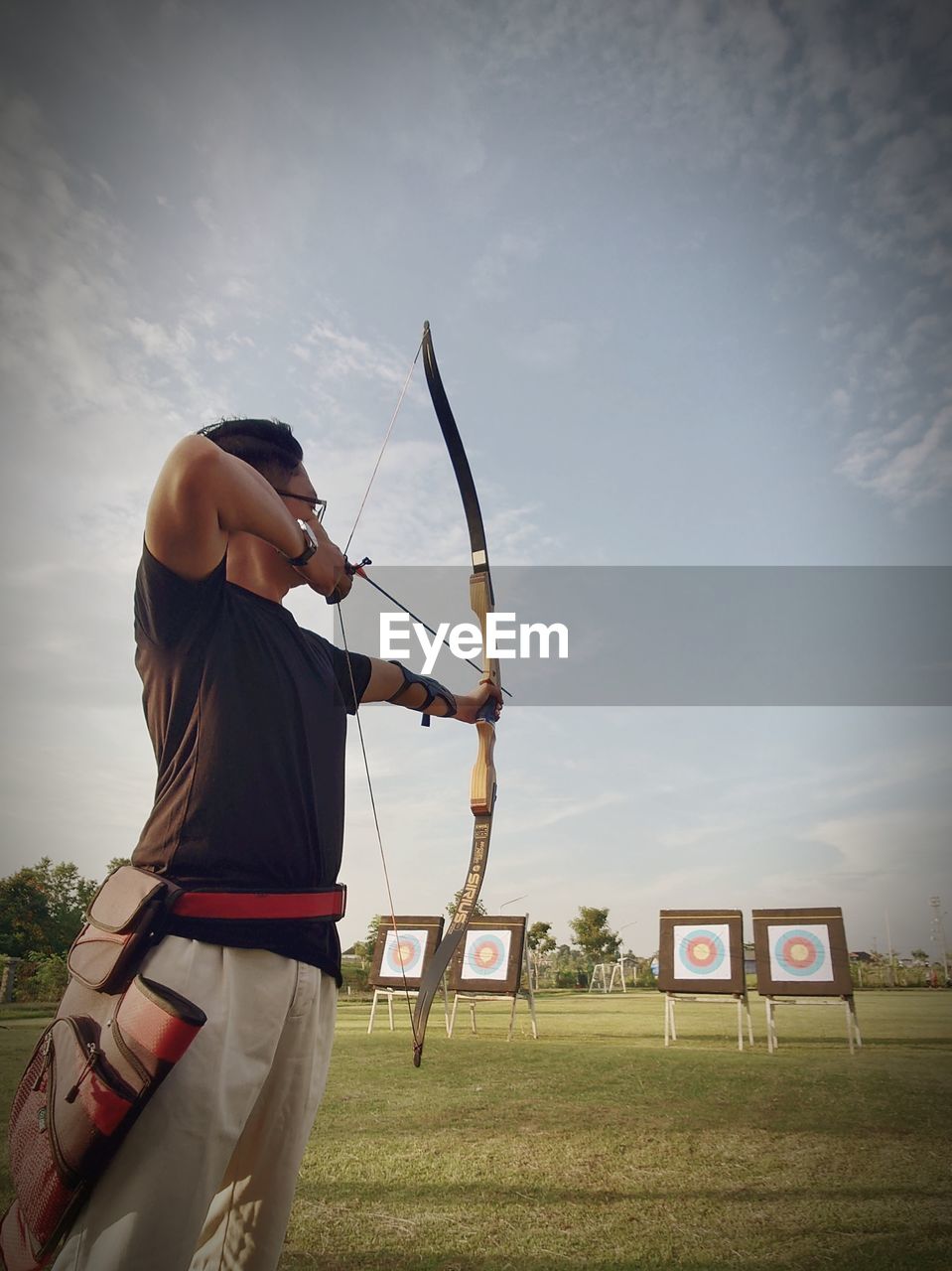 Archer holding bow and aiming for target