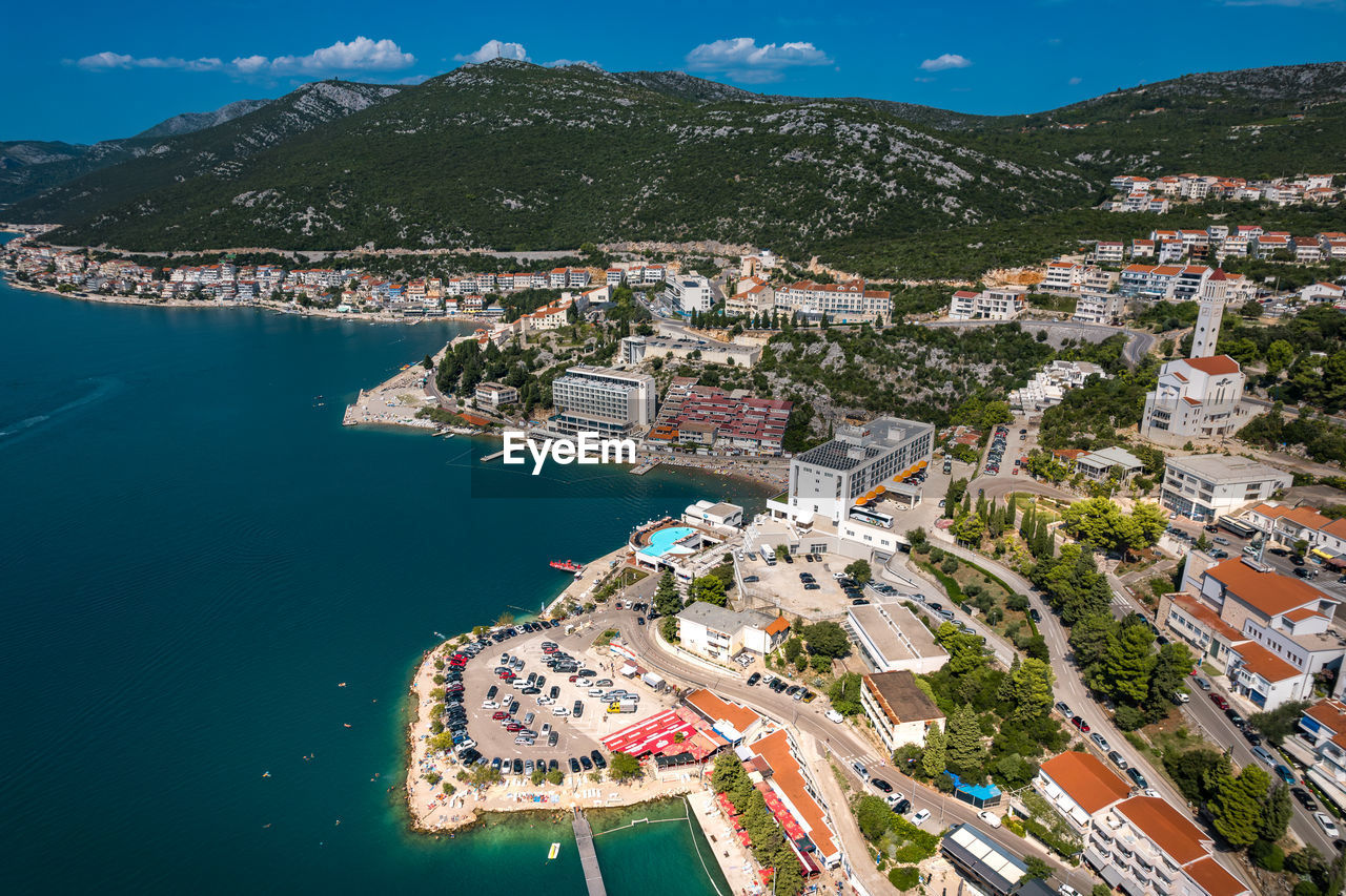 high angle view of cityscape by sea against sky