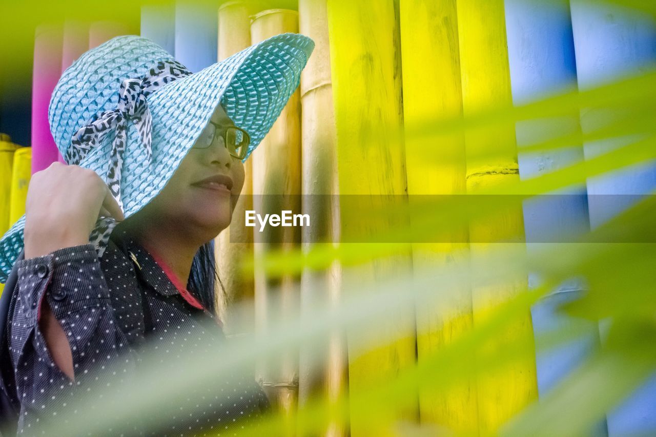 Woman looking away by bamboos