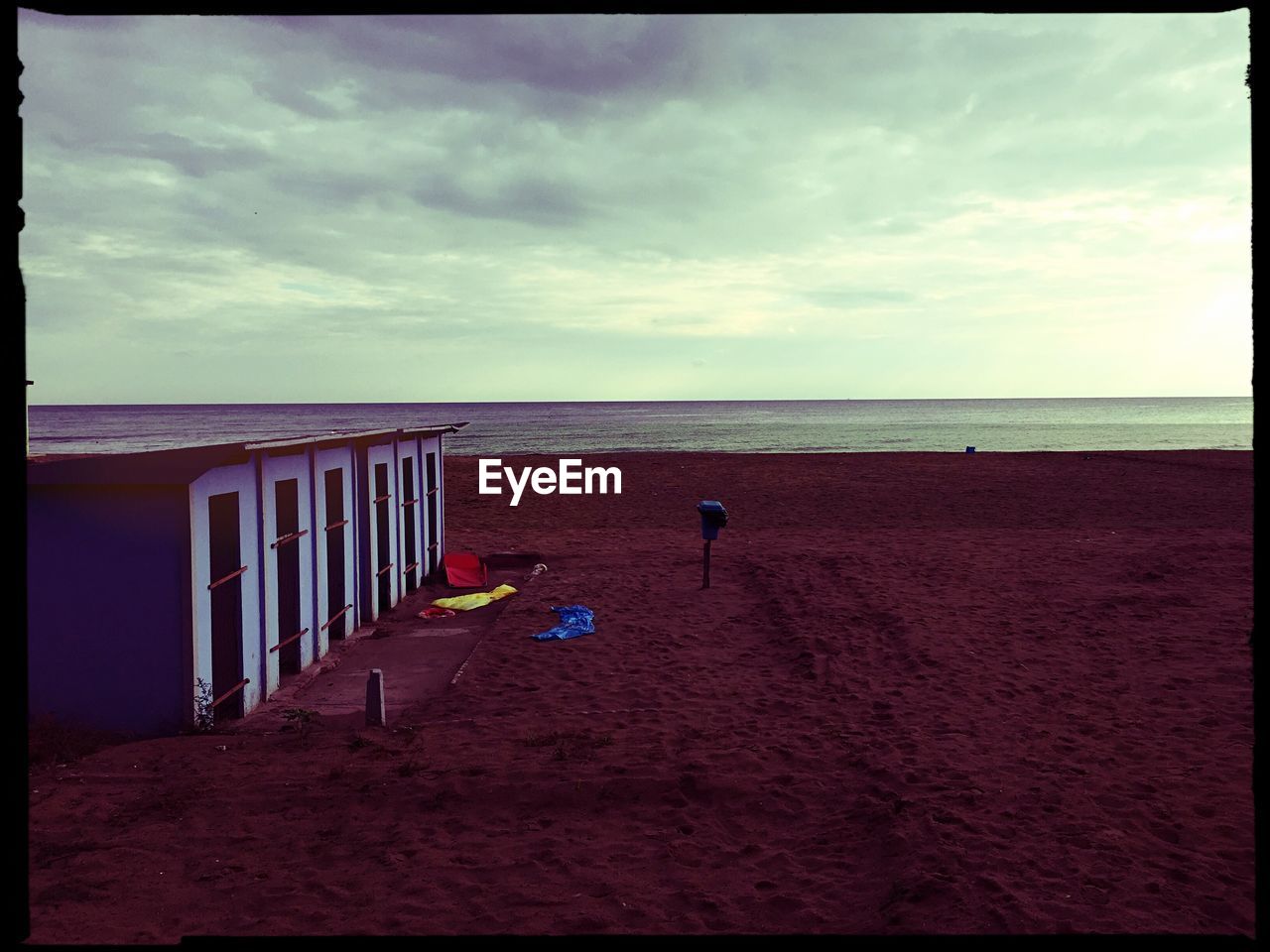 Beach huts against cloudy sky