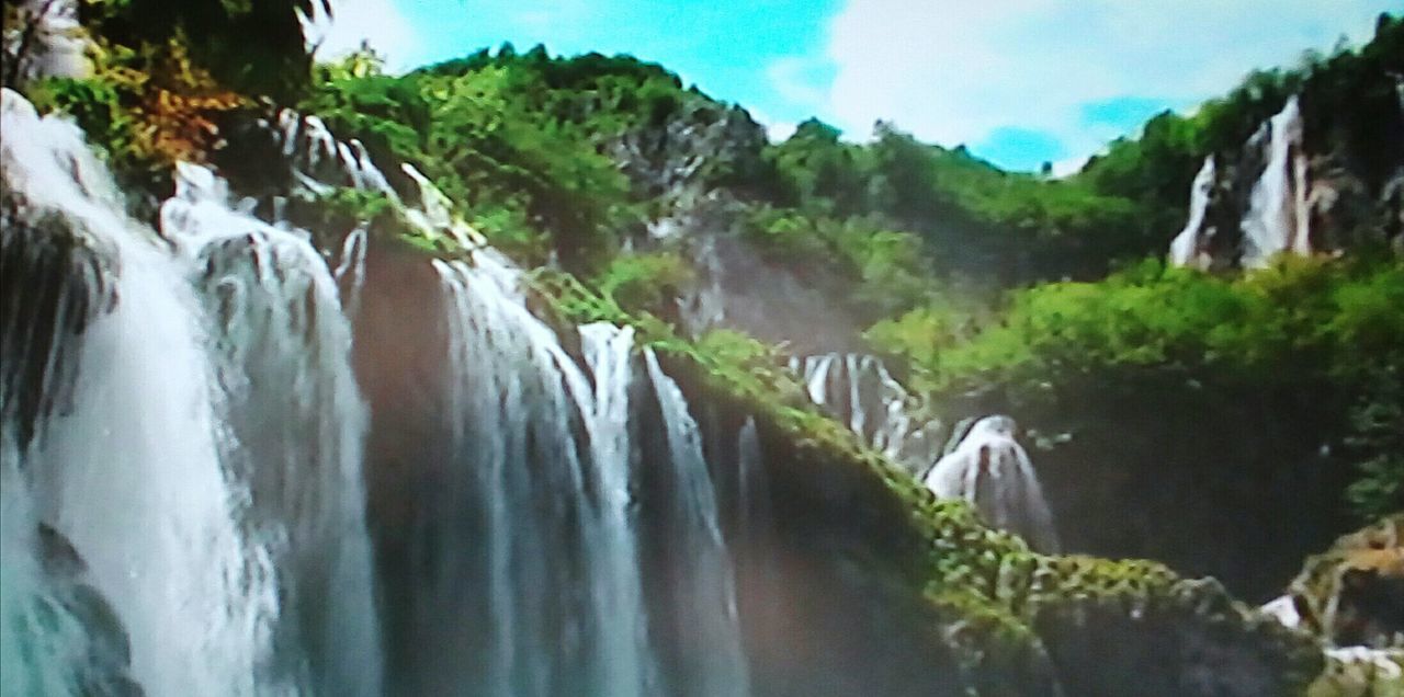 PANORAMIC VIEW OF WATERFALL AGAINST TREES