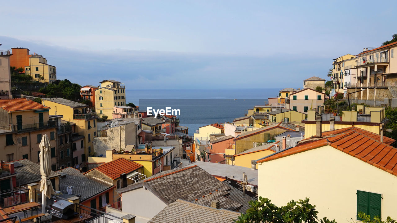 High angle view of houses by sea against sky