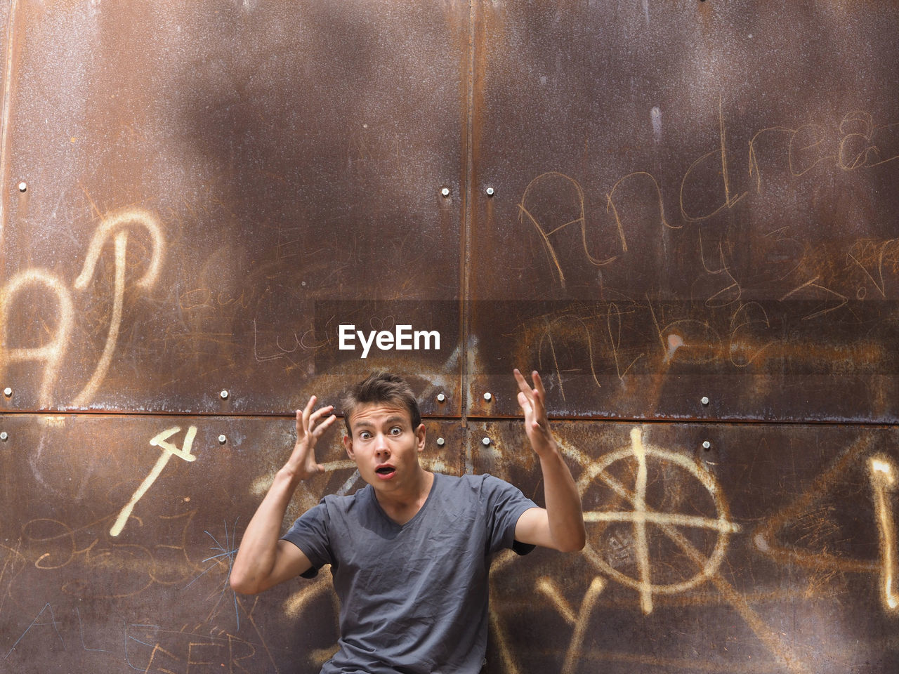 Portrait of shocked man against rusty metal