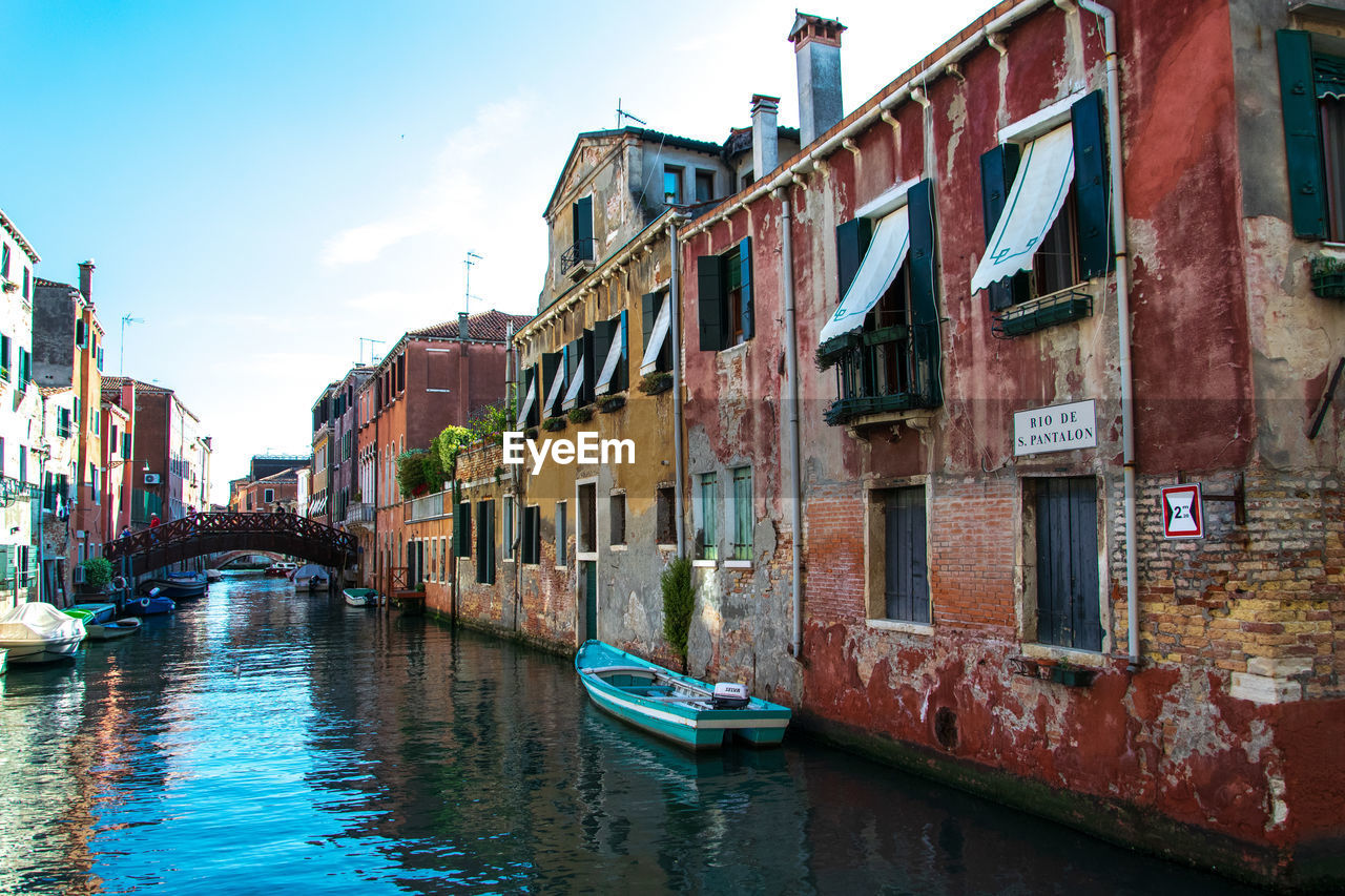 CANAL AMIDST BUILDINGS AGAINST SKY