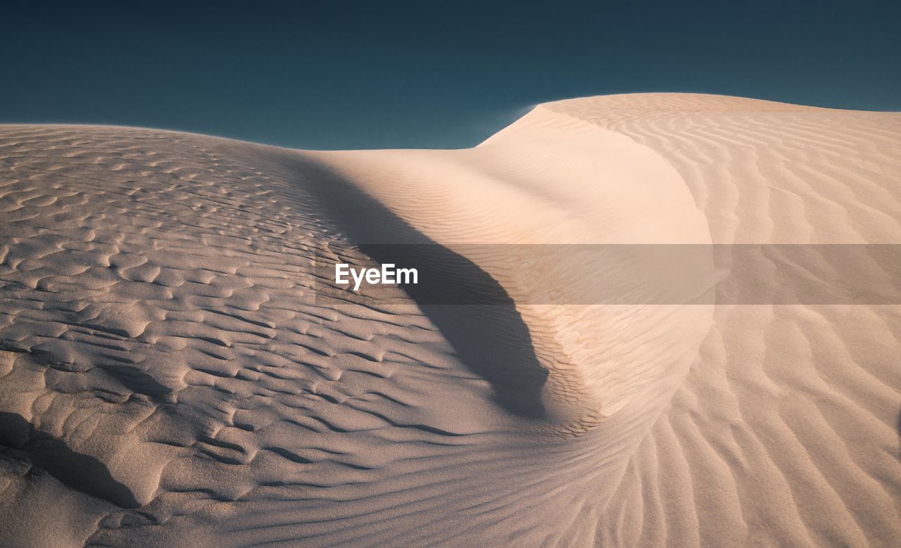 View of sand dunes in desert against sky