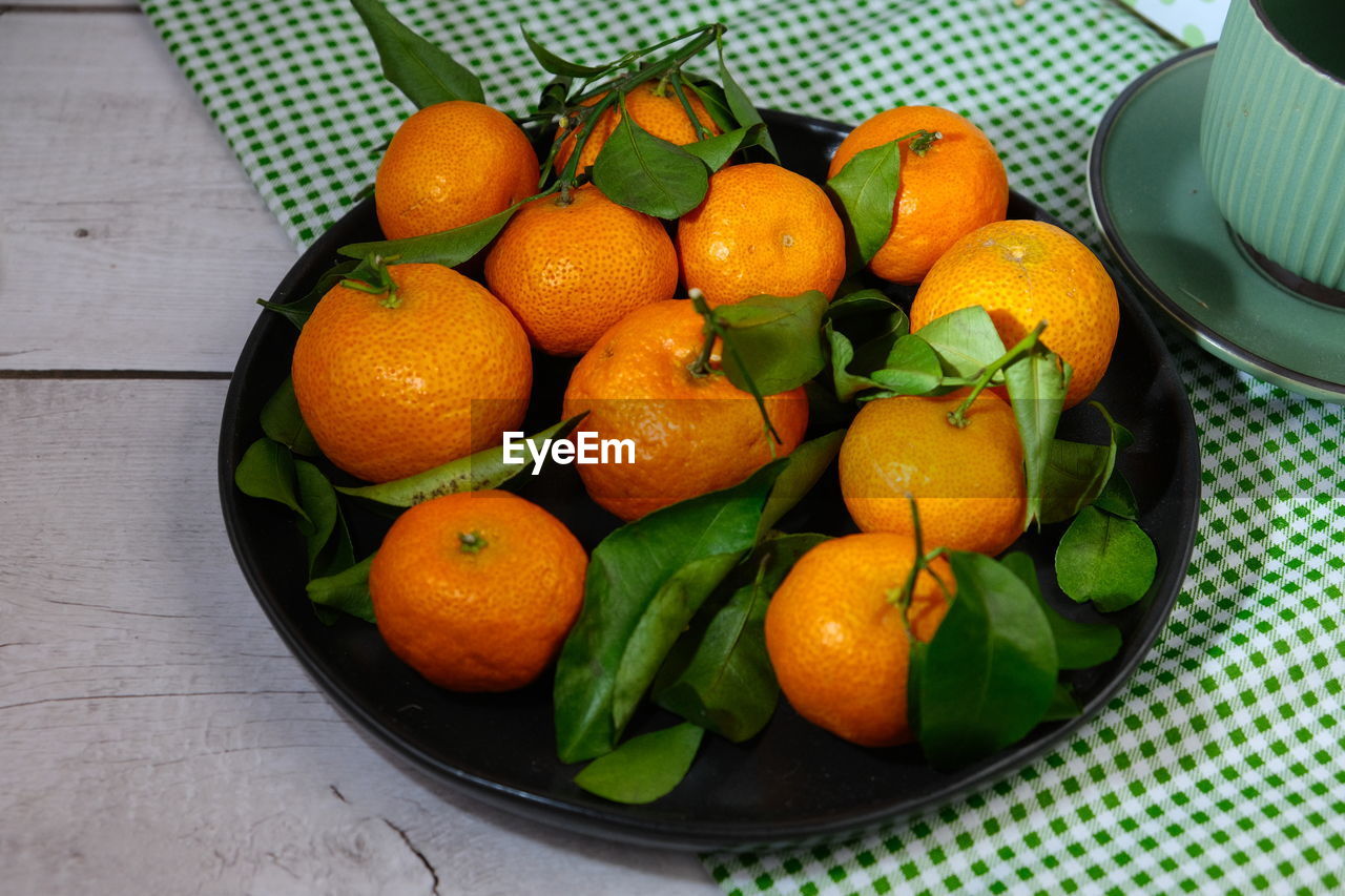 food and drink, food, healthy eating, citrus, fruit, freshness, produce, plant, wellbeing, clementine, citrus fruit, tangerine, orange color, orange, calamondin, high angle view, vegetarian food, no people, container, household equipment, leaf, basket, bowl, large group of objects, lemon, abundance, indoors, plant part, still life, organic, table, nature, directly above
