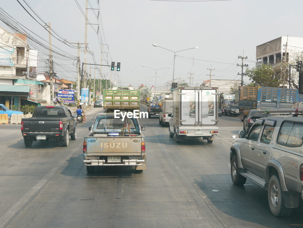 CARS ON ROAD BY BUILDINGS AGAINST SKY