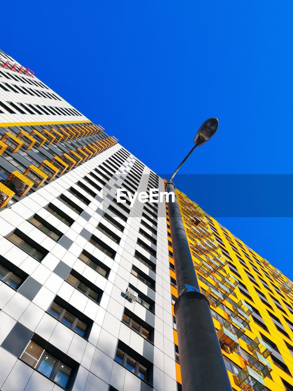 Low angle view of modern building against clear blue sky