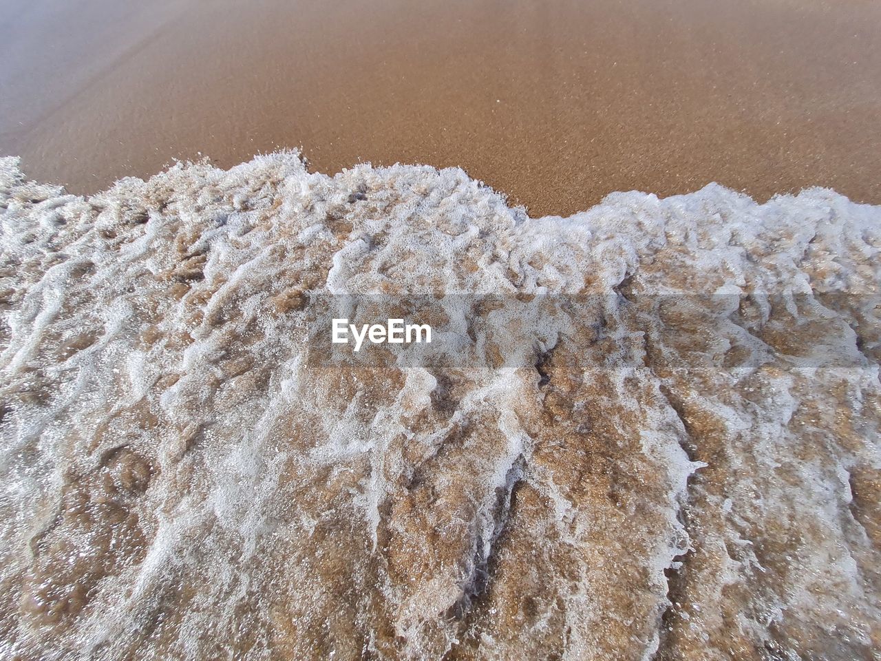 HIGH ANGLE VIEW OF SAND ON BEACH