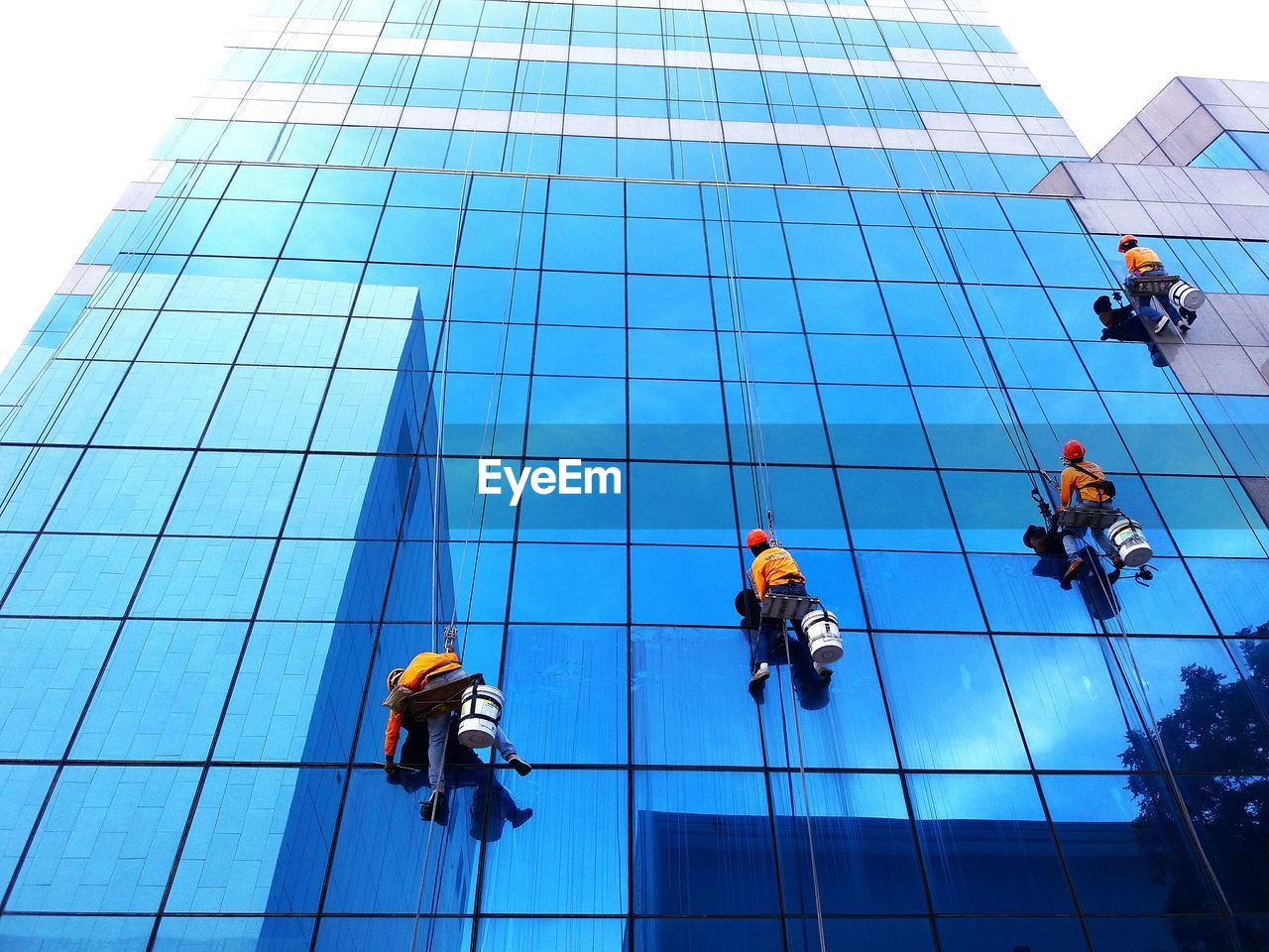 Low angle view of men working on building. cleaning worker