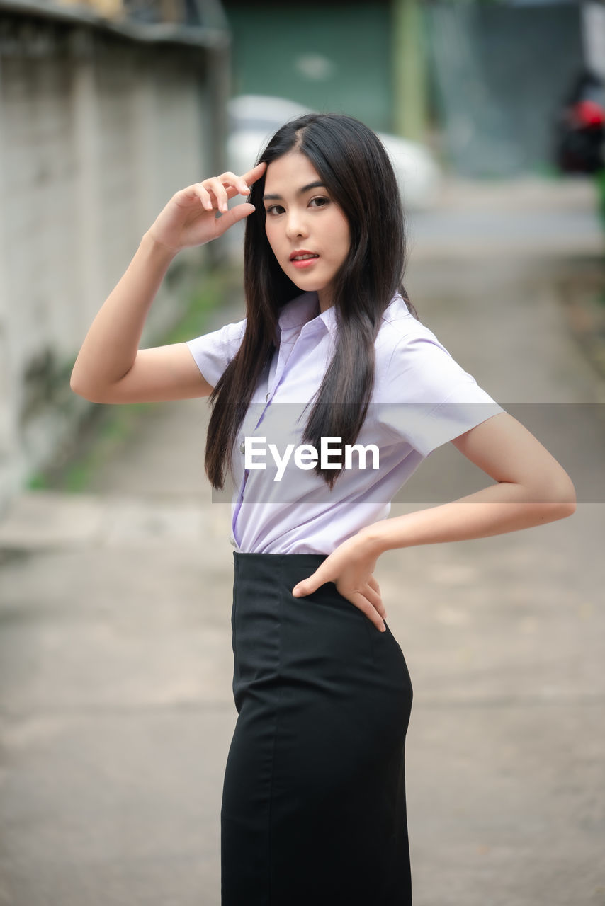 PORTRAIT OF A BEAUTIFUL YOUNG WOMAN STANDING OUTDOORS