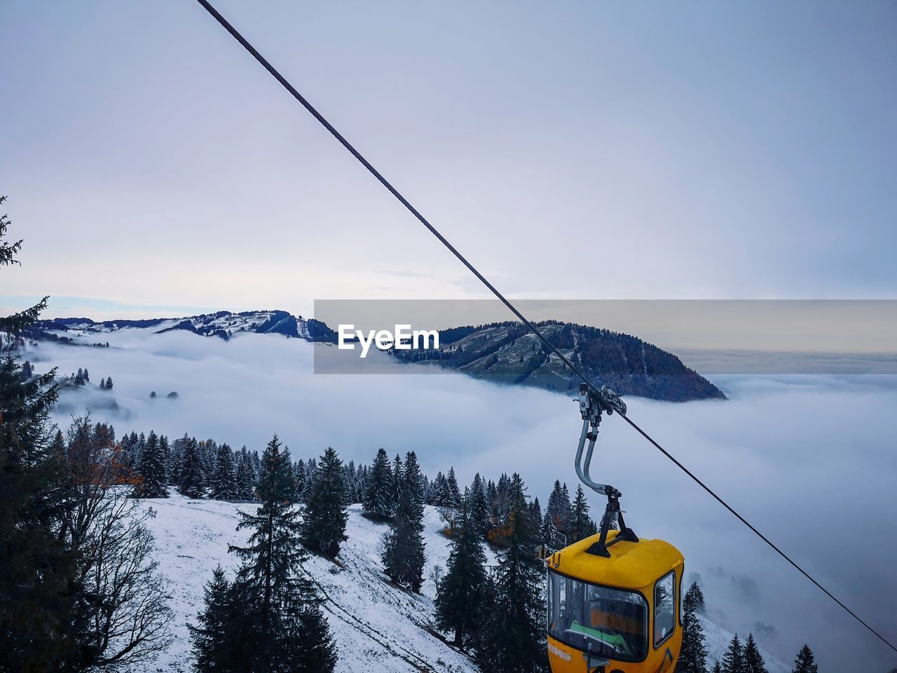 LOW ANGLE VIEW OF SKI LIFT AGAINST SNOWCAPPED MOUNTAINS