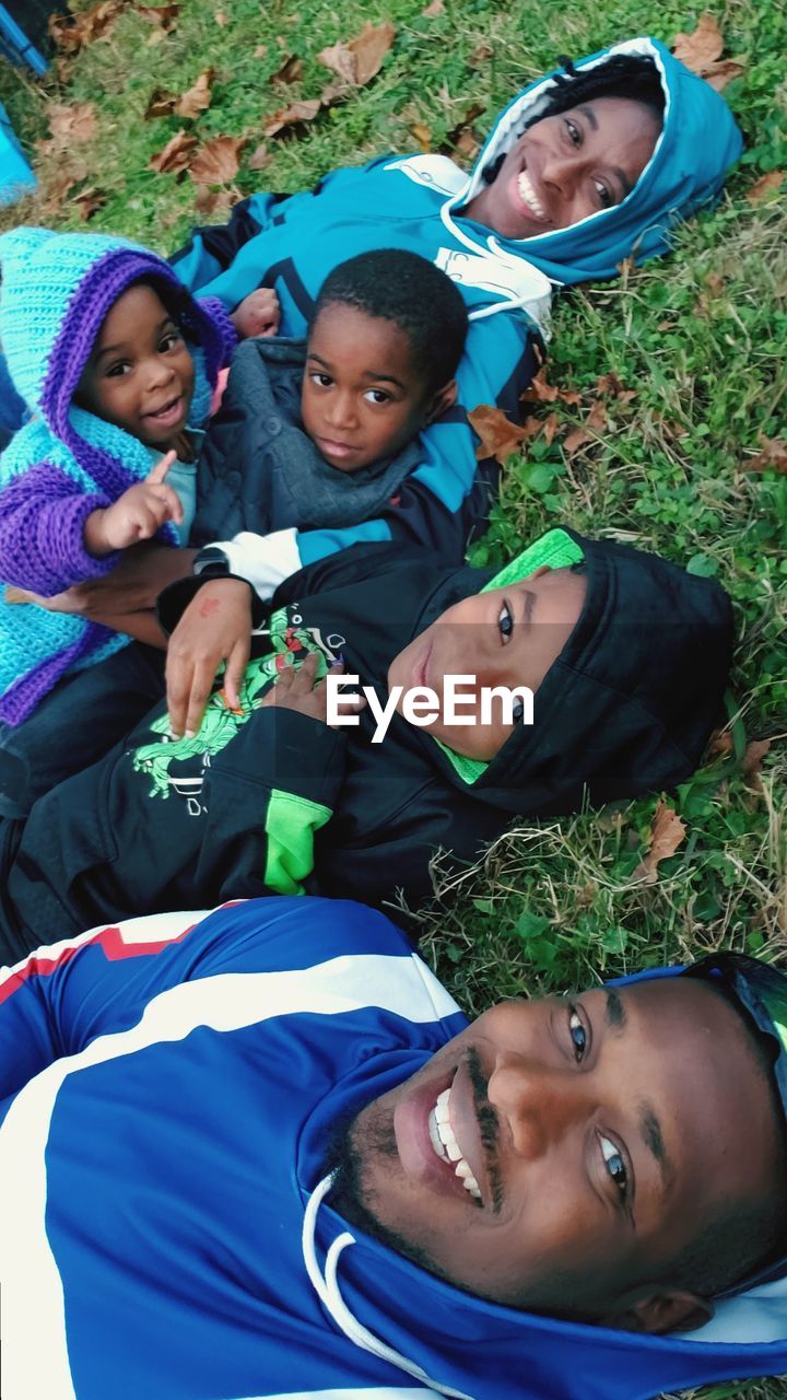 High angle portrait of smiling family relaxing in park