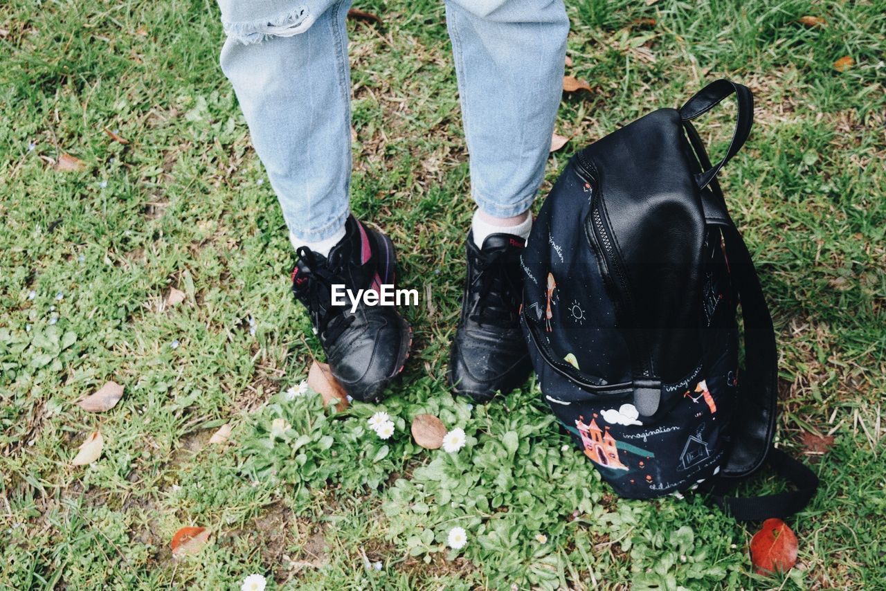 LOW SECTION OF MAN WEARING SHOES ON FIELD