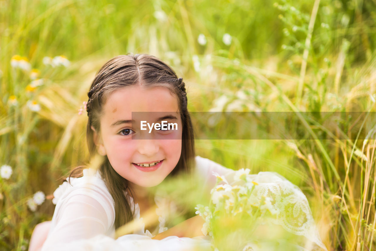 Portrait of girl sitting on field