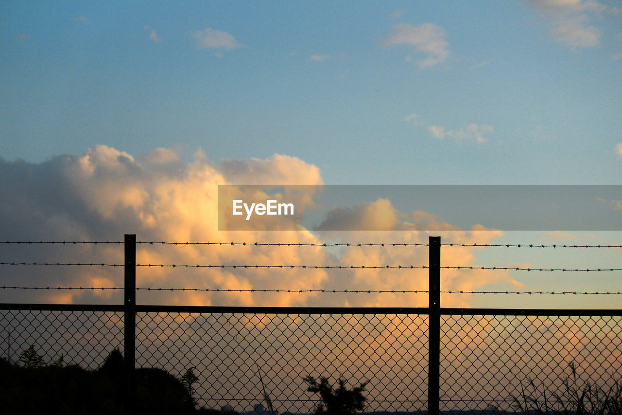 SILHOUETTE FACTORY AGAINST SKY AT SUNSET