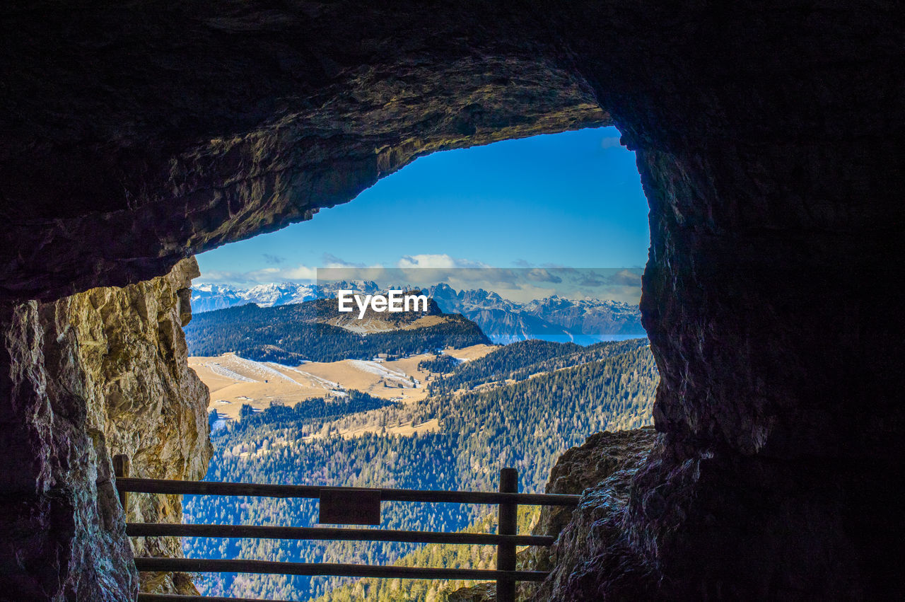 Scenic view of mountains against sky seen through cave