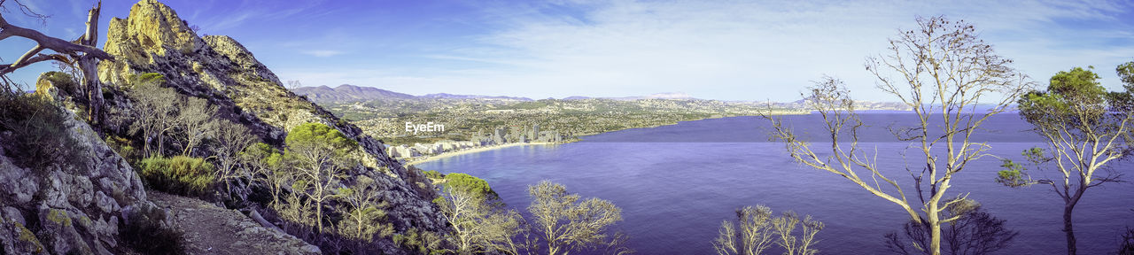 Panoramic view of trees and mountains against sky